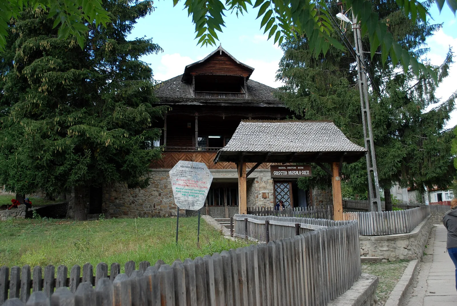 The wooden house of the Colți museum collection, with the museum sign above the gate.