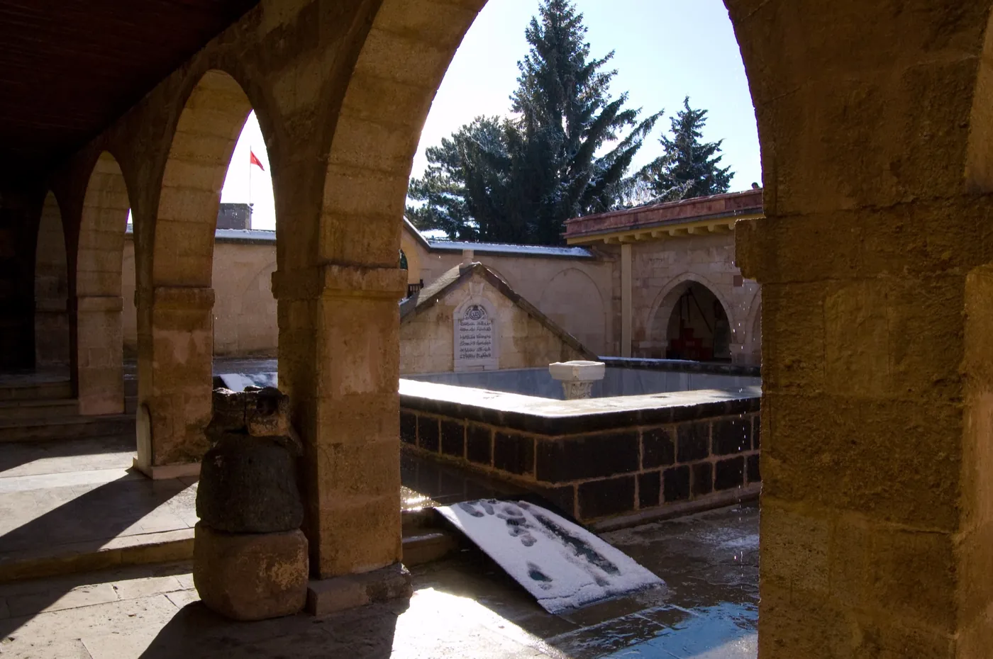 Colonadă de piatră în jurul unei curți cu fântână în complexul de la Hacıbektaş