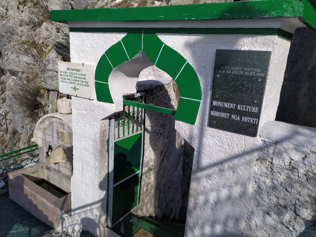 Monumentul lui Sari Salltik la Krujë: o nișă albă cu arc verde și o placă