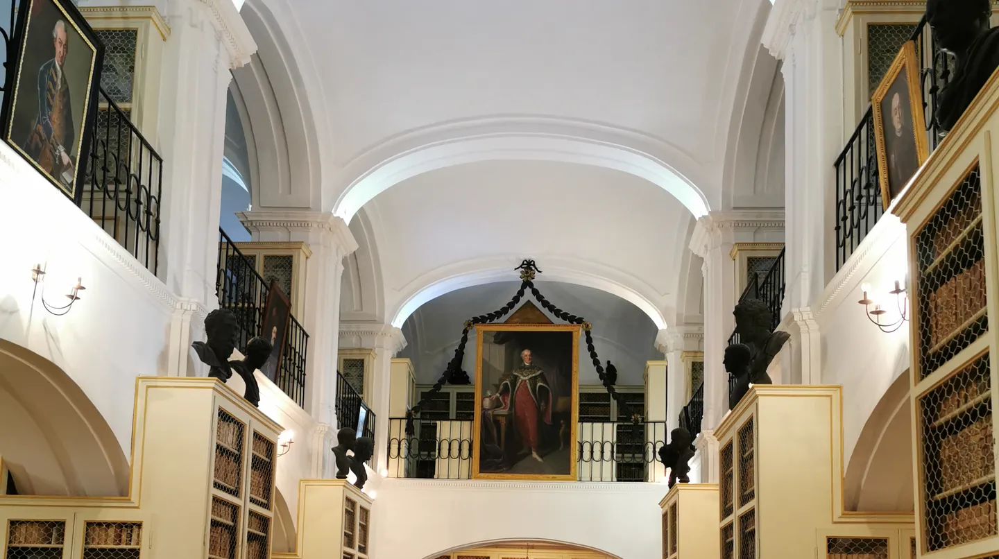 Sala mare a bibliotecii, cu galeria, busturile și rafturile cu cărți vechi