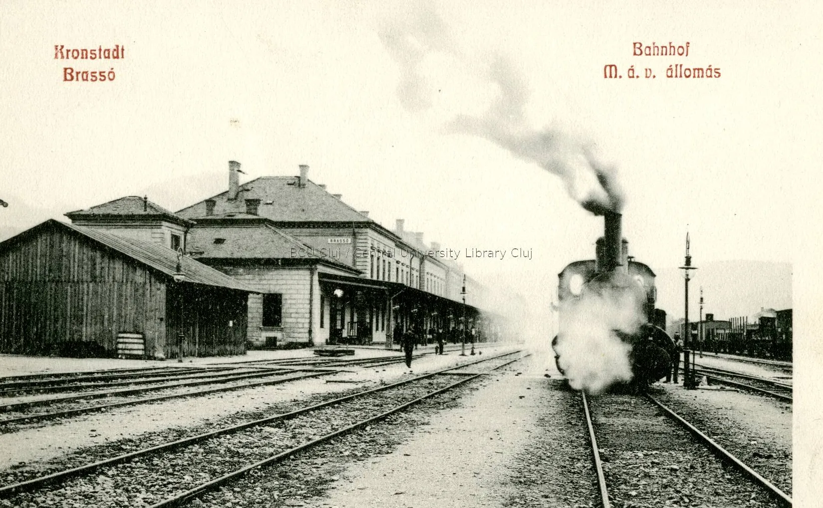 Postcard: a steam locomotive enters the station, beside the building with a covered platform