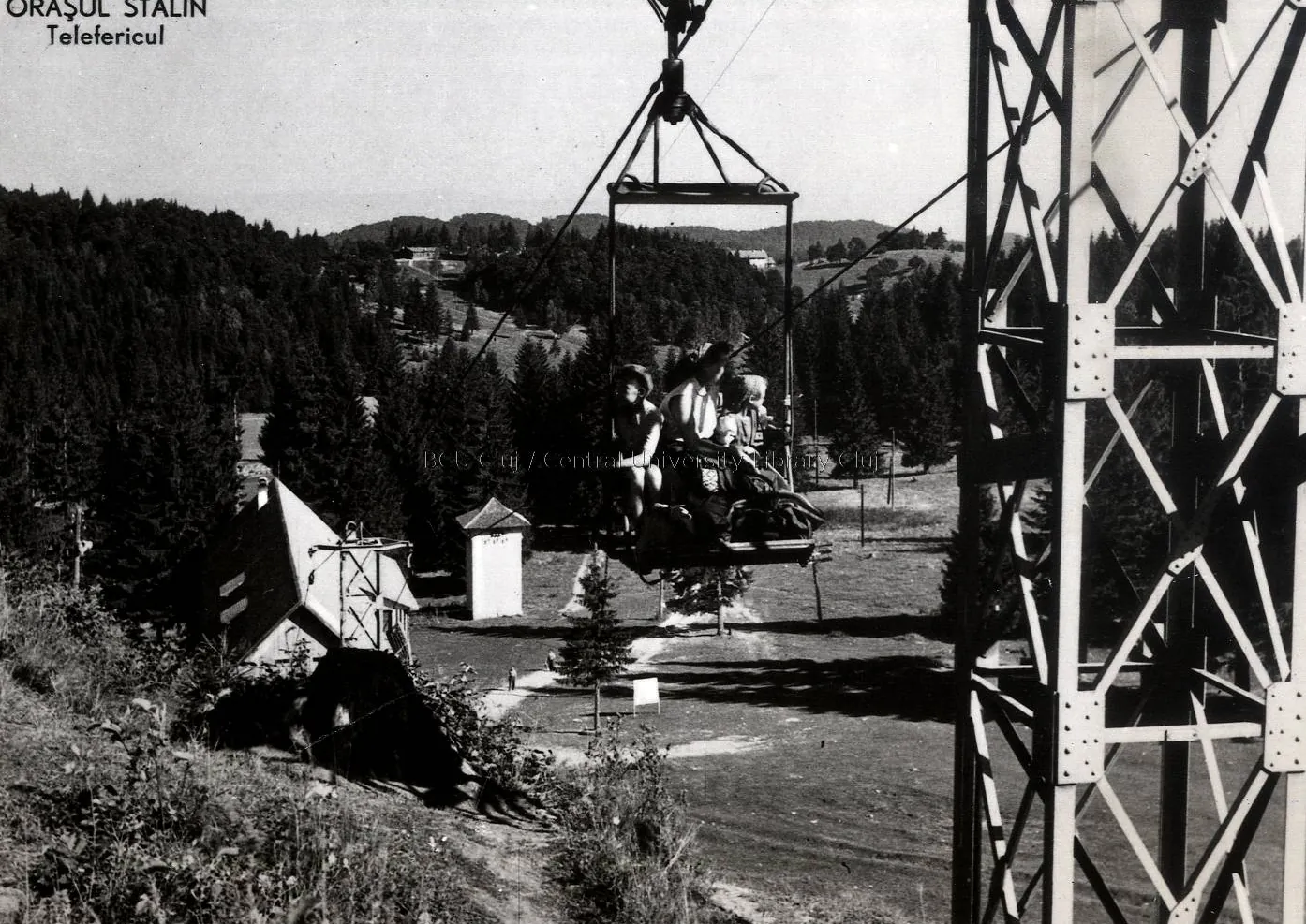 Black-and-white illustrated card: a cable-car cabin beside a metal pylon, above the forest