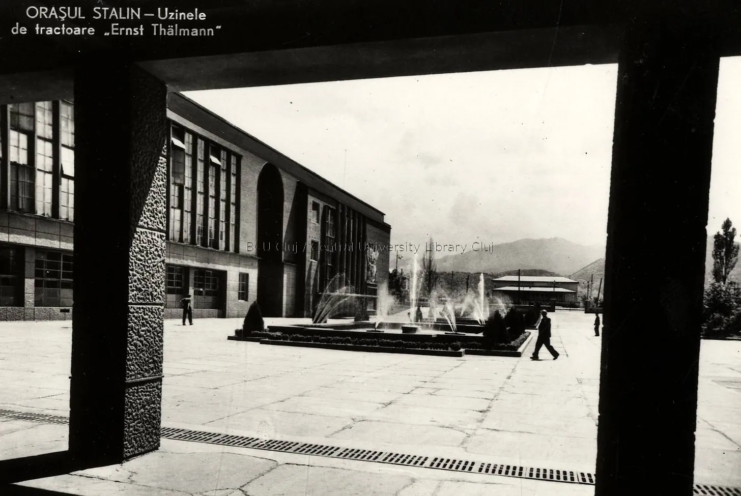 Black-and-white illustrated card: the modernist entrance of a factory, seen between pillars