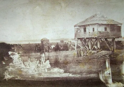 Fotografie veche, sepia, a clădirilor carantinei de la Oltenița, pe malul Dunării