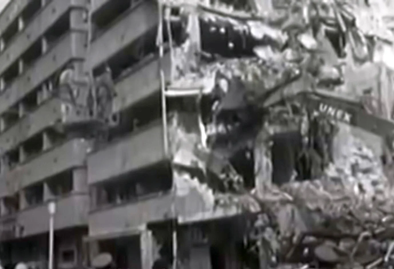 Bloc prăbușit în București după cutremurul din 4 martie 1977, cu oameni și utilaje în jurul ruinelor