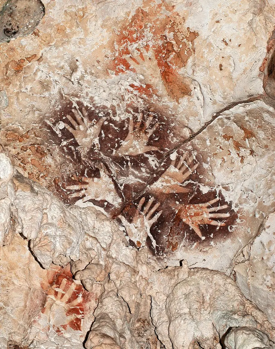 Six hand stencils arranged in a ring on a limestone wall in Borneo