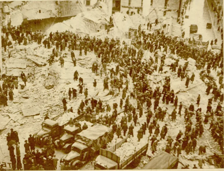 Crowds of rescuers and onlookers on the ruins of the Carlton Block a few days after the earthquake of 10 November 1940; trucks in the foreground.