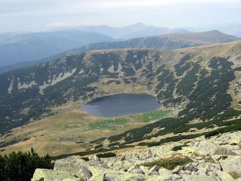 Zănoaga Mare, un lac glaciar întunecat într-o căldare din Munții Retezat.