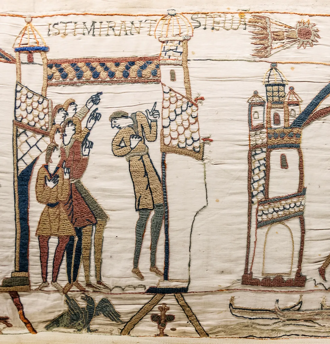 Embroidered men pointing up at a star with a long tail, under the Latin words ISTI MIRANT STELLA.