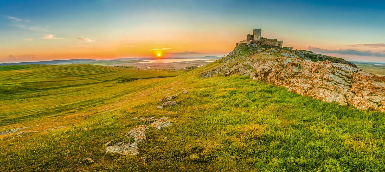 Cetatea Enisala la apus, pe creasta de calcar, cu laguna Razim în spate.