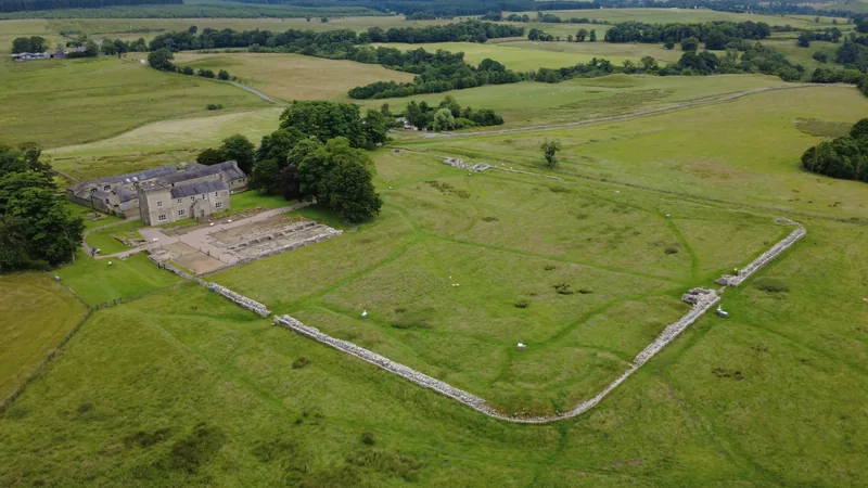 Aerial view of Birdoswald fort: the fort's rectangular outline with the farm beside it, above the River Irthing.