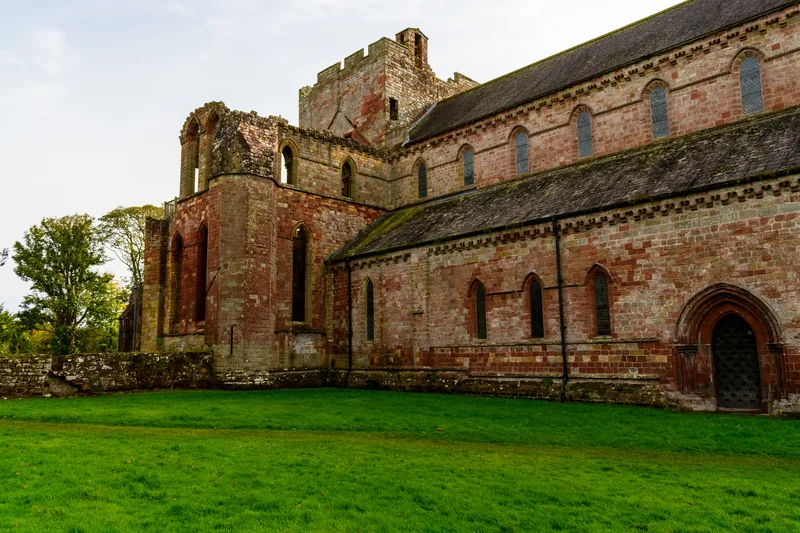 The ruins of Lanercost Priory: the church's tall arches, partly built of reused Roman stone.