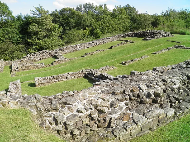 Milecastle 48 (Poltross Burn): enclosing walls and one of the gates, among trees.