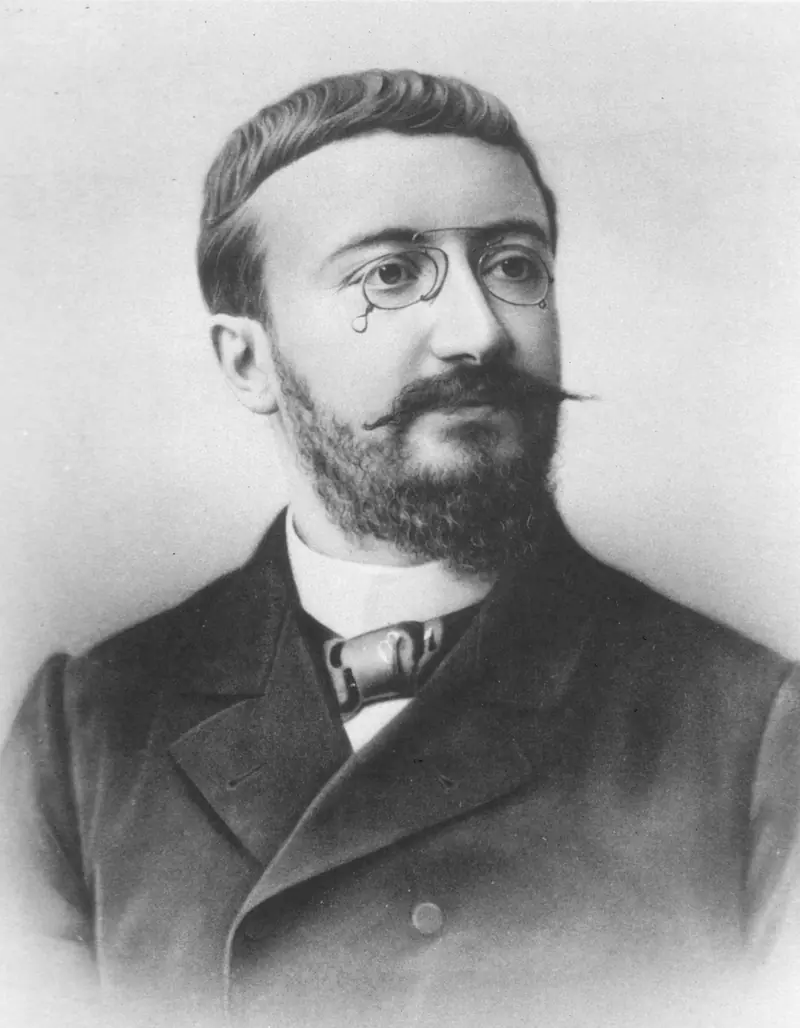 Black-and-white portrait of a bearded man with glasses.