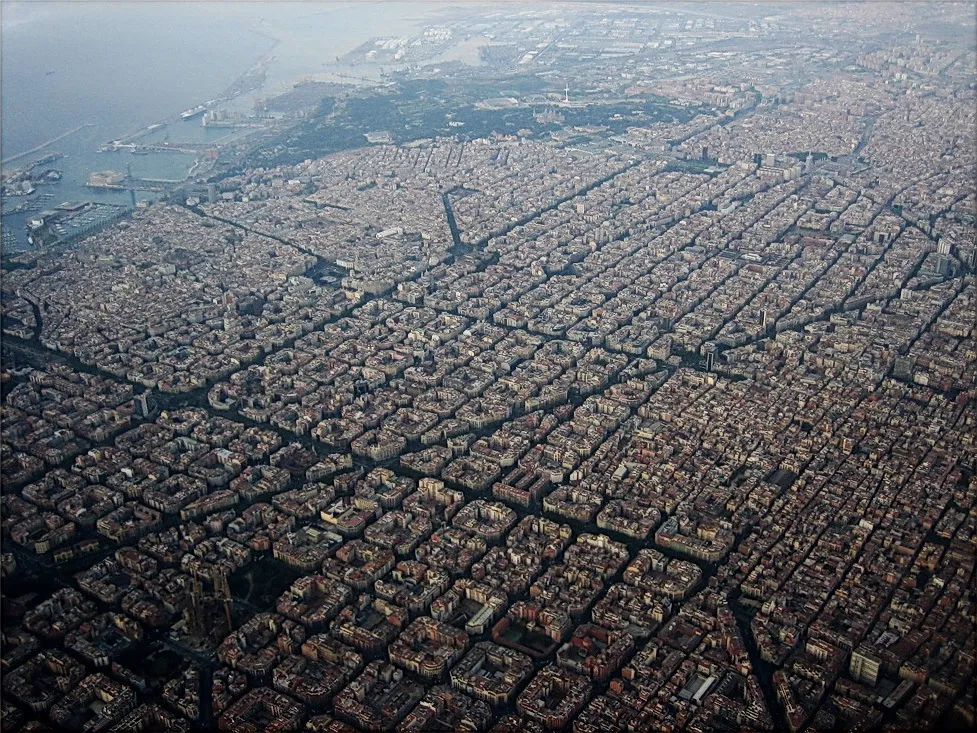 Fotografie aeriană a Eixample-ului, cu cvartale pătrate închise și curți interioare construite.