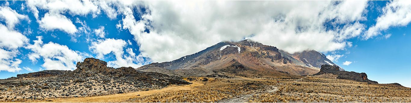 Panoramă largă a rutei Lemosho, cu masivul Kilimanjaro sub nori