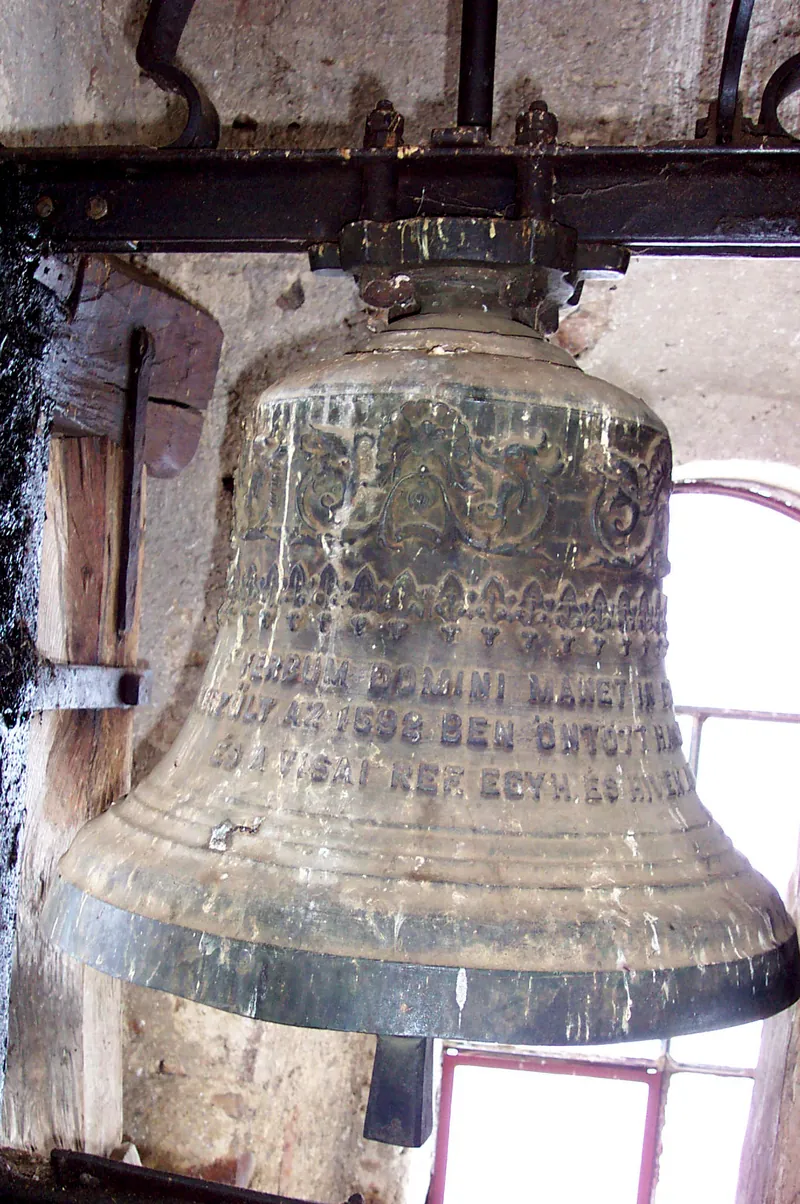 A large bronze bell hanging in a belfry