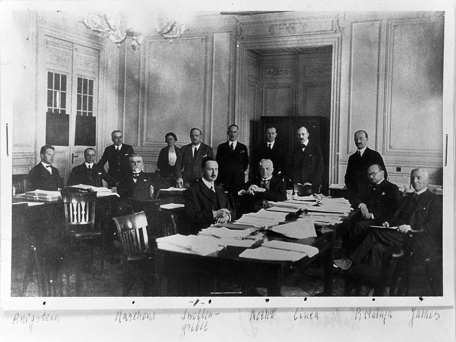 Fotografie de grup: delegați în jurul unei mese de conferință.