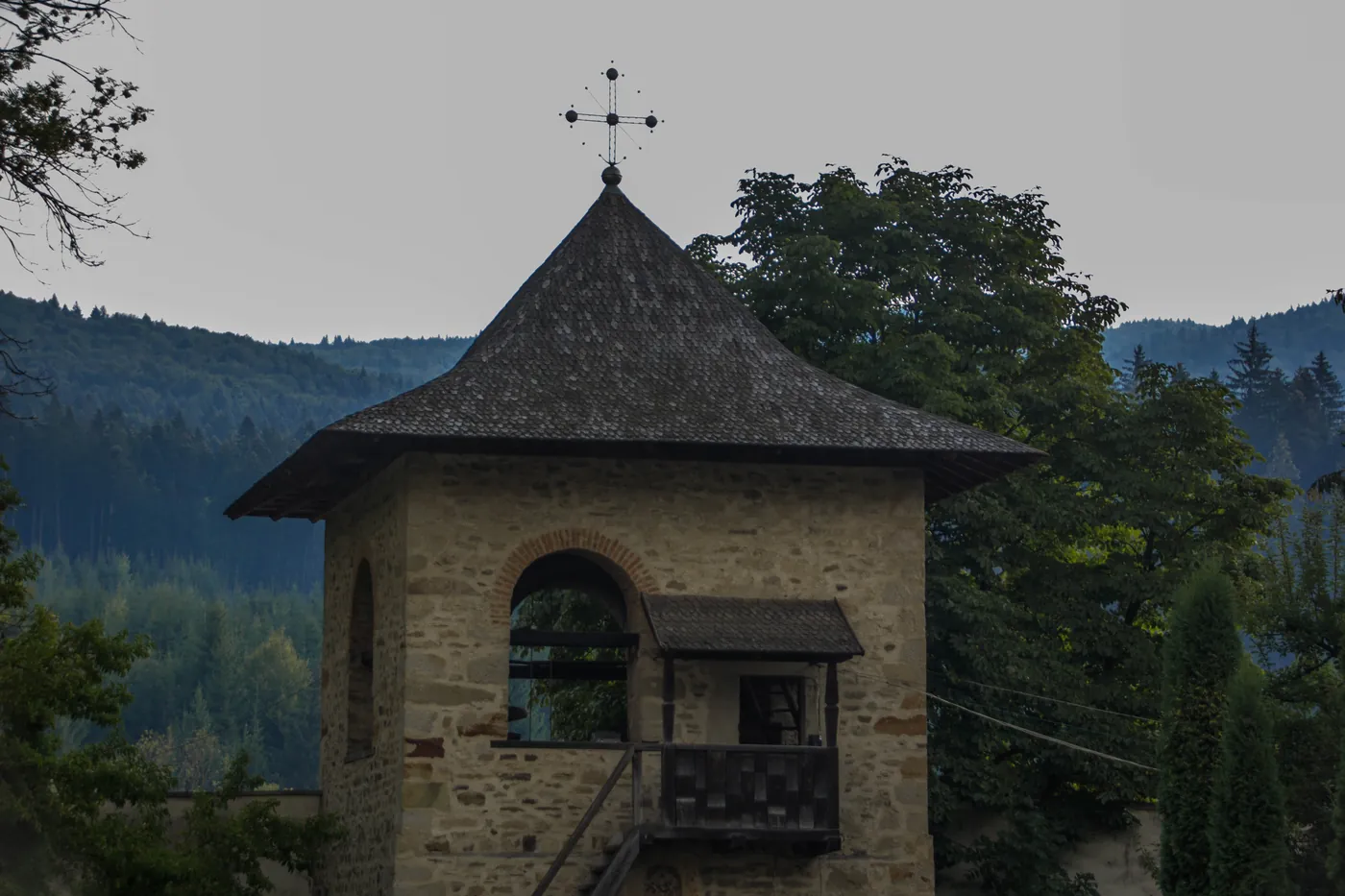 Clopotnița de piatră a Voronețului, cu crucea pe cer de codru.