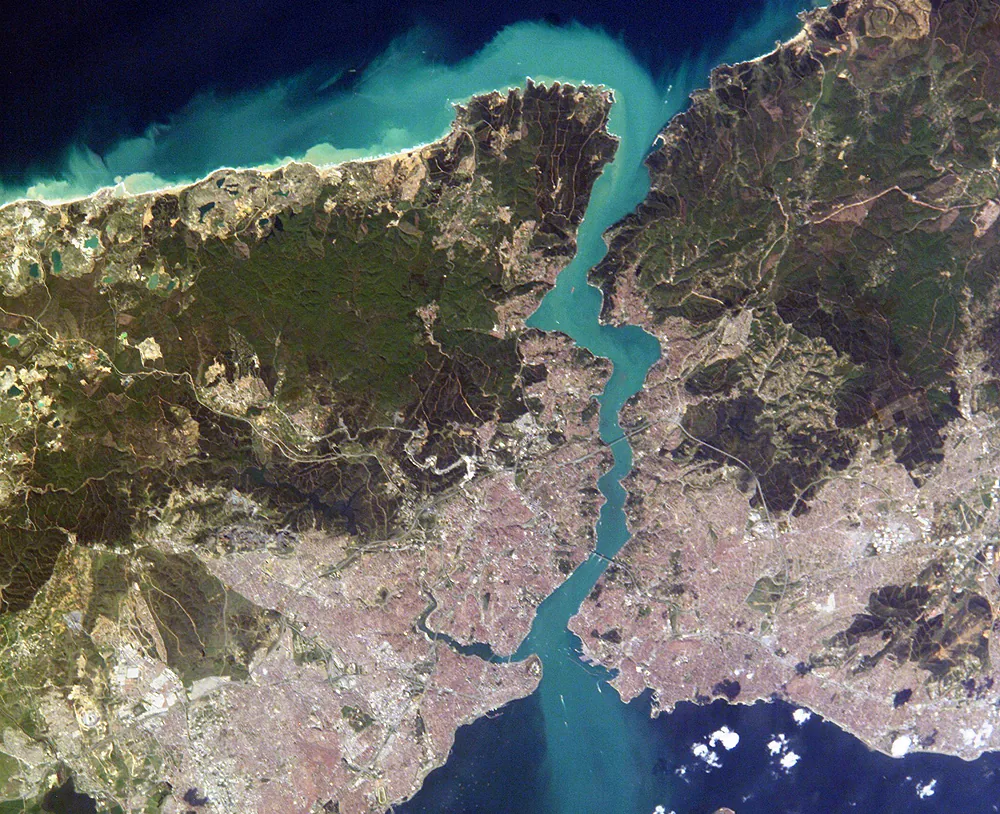Fotografie din satelit: strâmtoarea Bosfor, o panglică îngustă de apă între Marea Neagră și Marea Marmara, cu Istanbulul pe ambele maluri.
