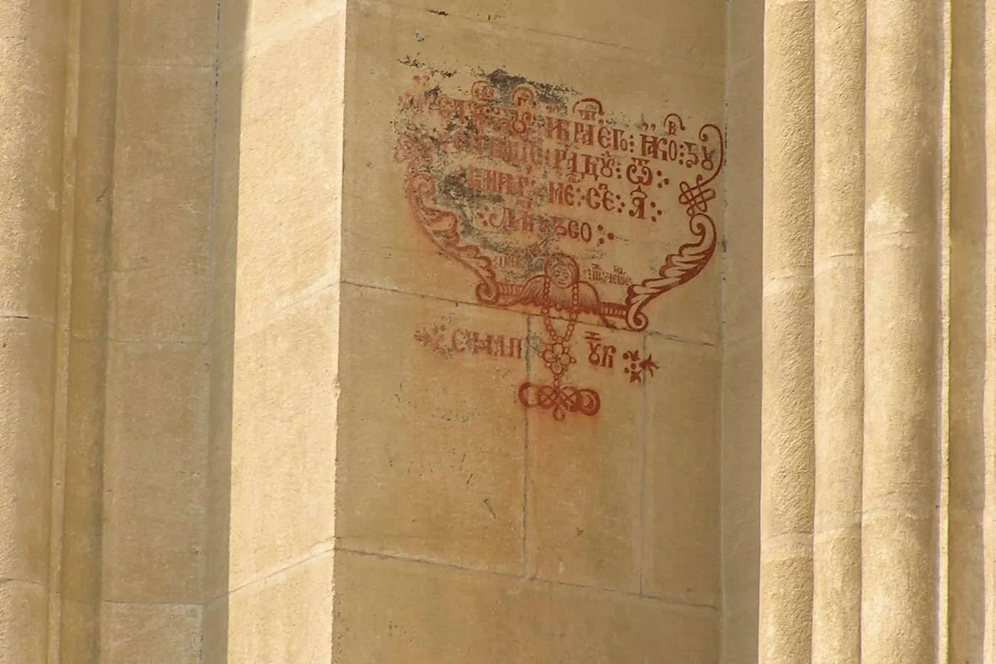 The church wall today, with its red lettering and stone frames.