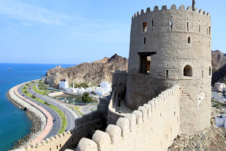 Fortul Mutrah pe stâncă, deasupra portului vechi din Muscat, cu corniche în față.