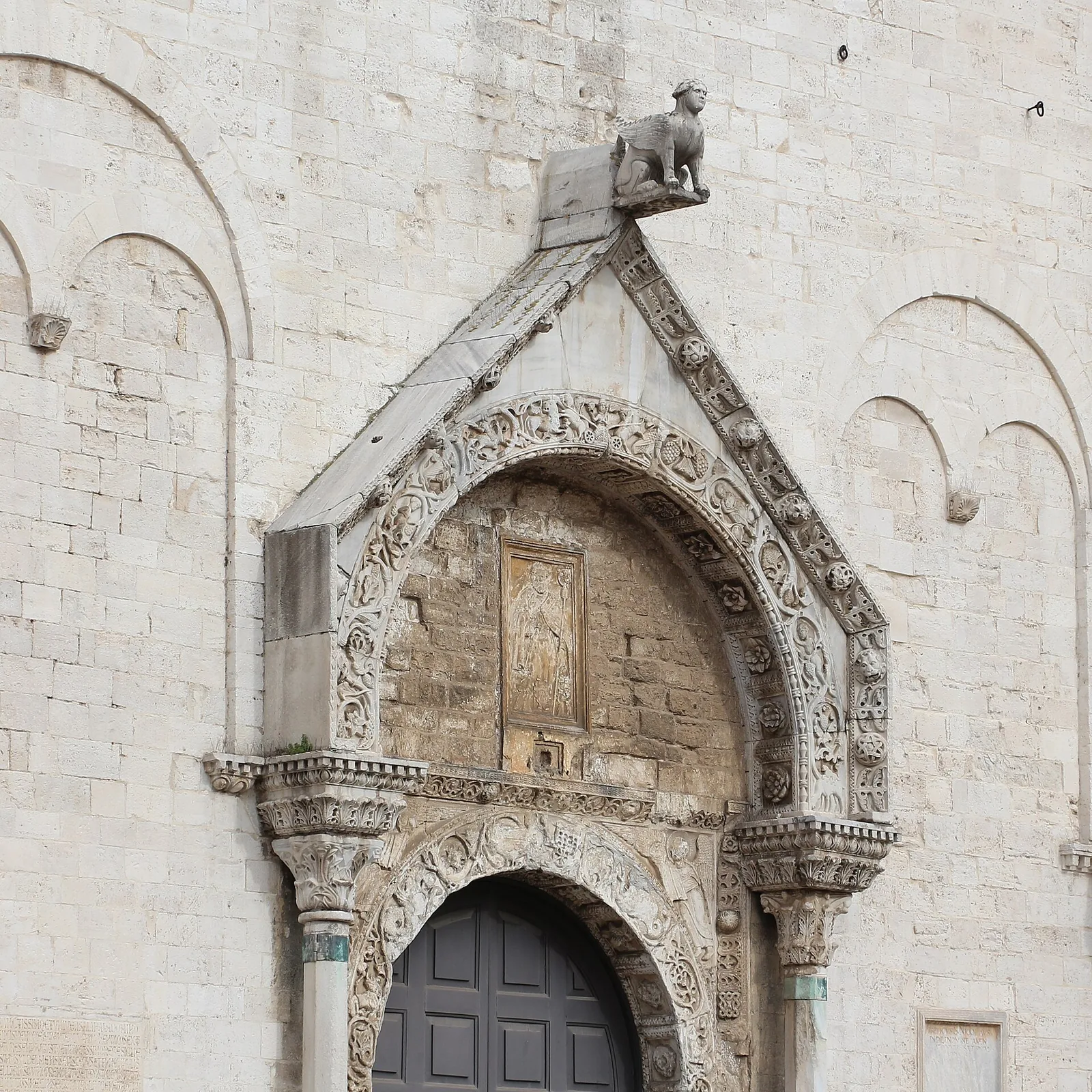 Portal de piatră sculptată al unei biserici romanice.