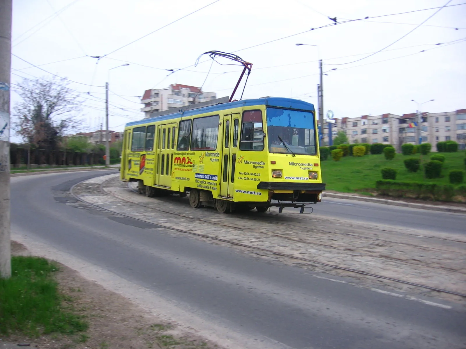 A yellow Tatra tram on a curve in Craiova