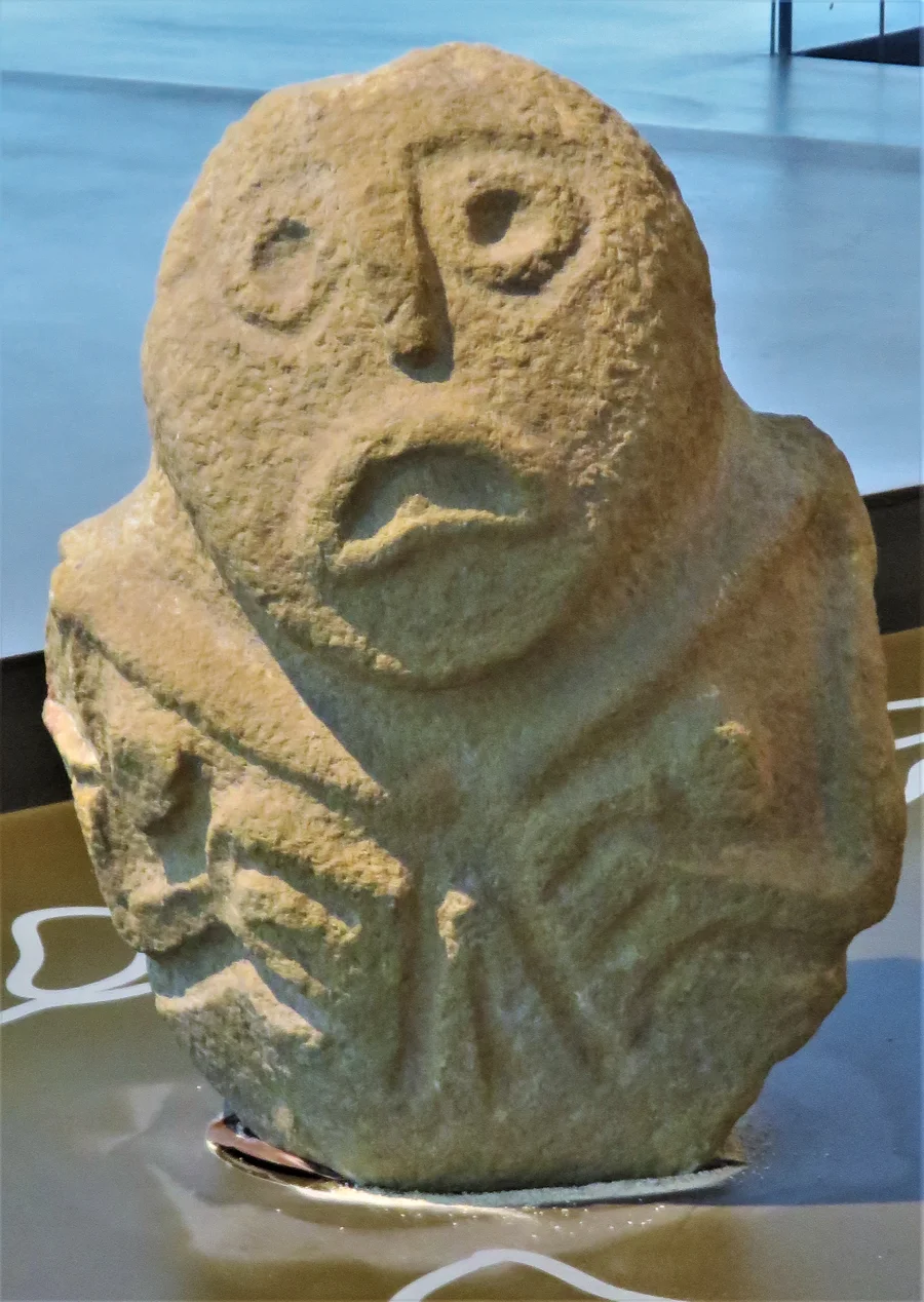 An anthropomorphic stone sculpture from Lepenski Vir, photographed in a museum.