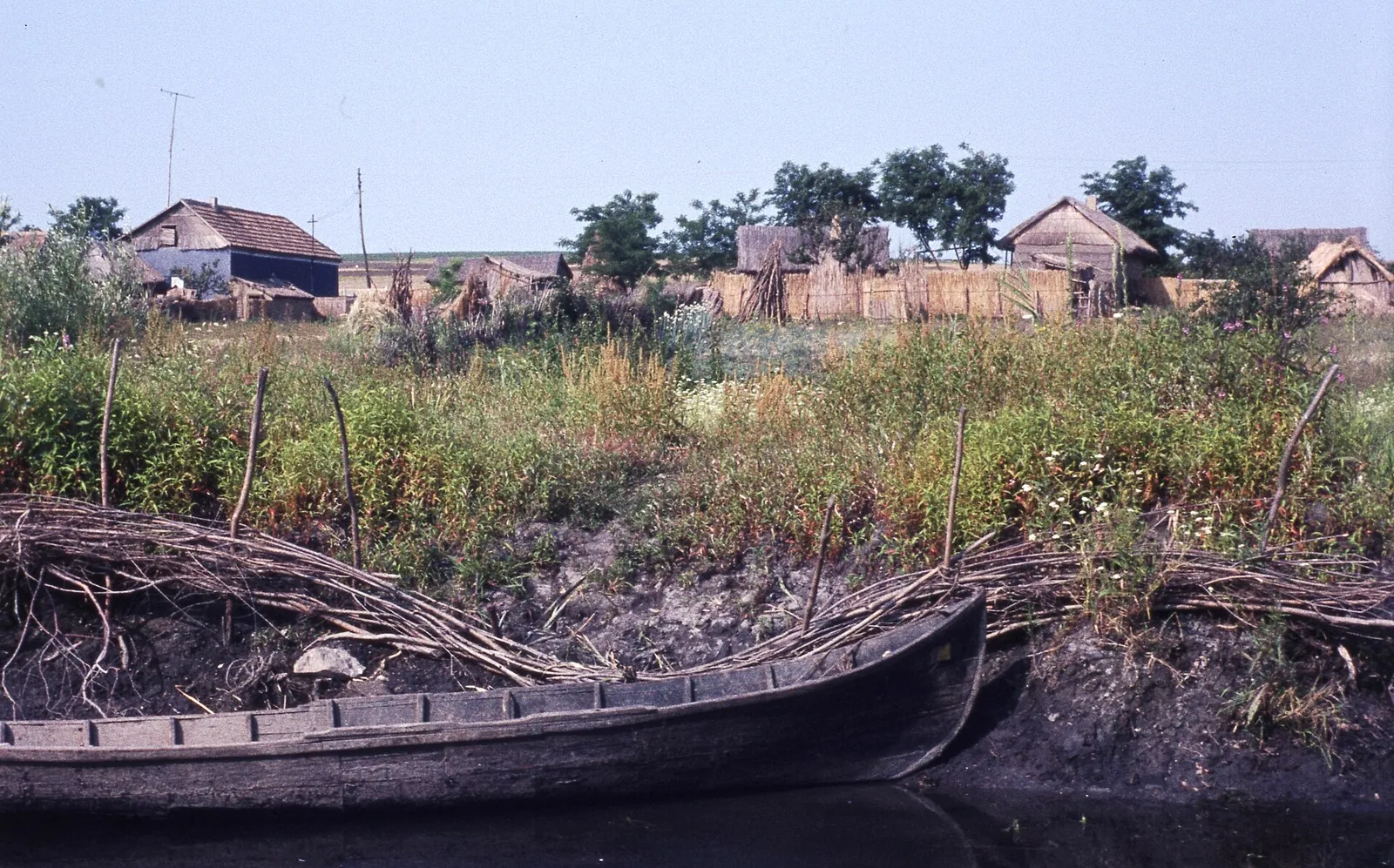Case și bărci de pescari pe un canal al Deltei Dunării în 1976