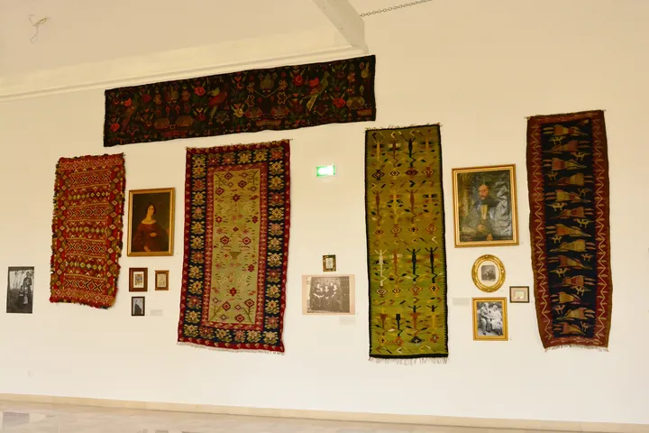 Romanian folk carpets exhibited in a museum hall.