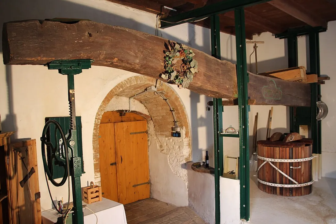 A wooden tree press with its screw, in a cellar