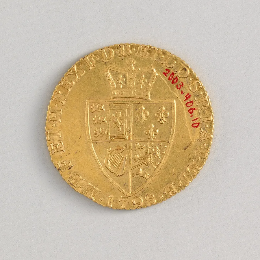 Reverse of a gold guinea dated 1798: a crowned shield with a ring of abbreviated Latin letters around it.