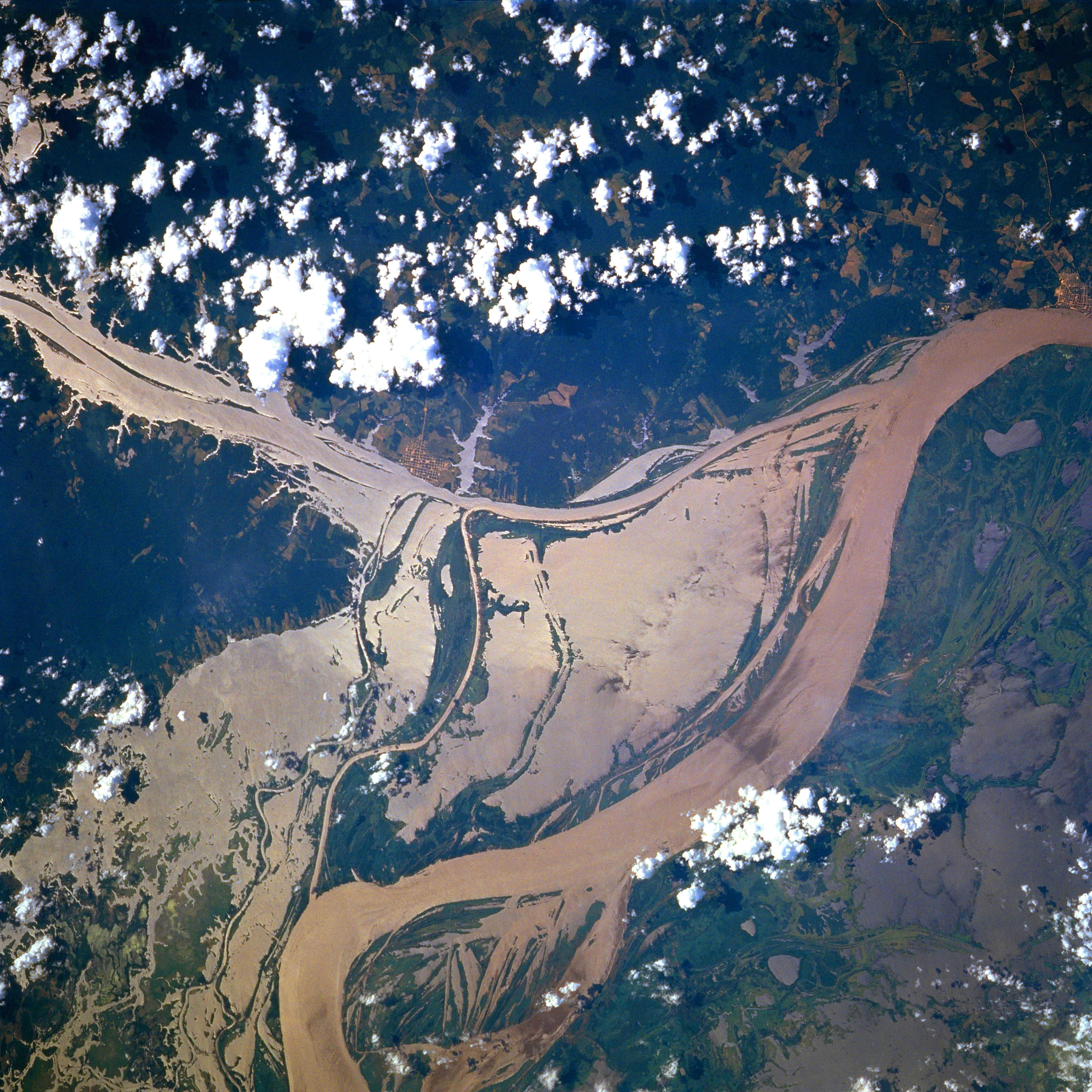 Satellite photograph of a flooded section of the Amazon River, with broad muddy channels, forest islands, and smaller waterways branching through the floodplain.